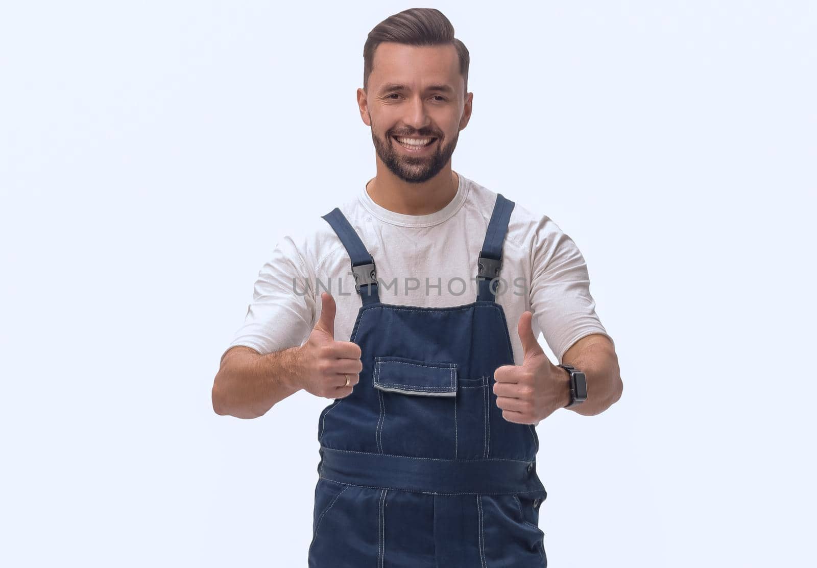 in full growth. friendly man in overalls showing thumbs up. isolated on white background