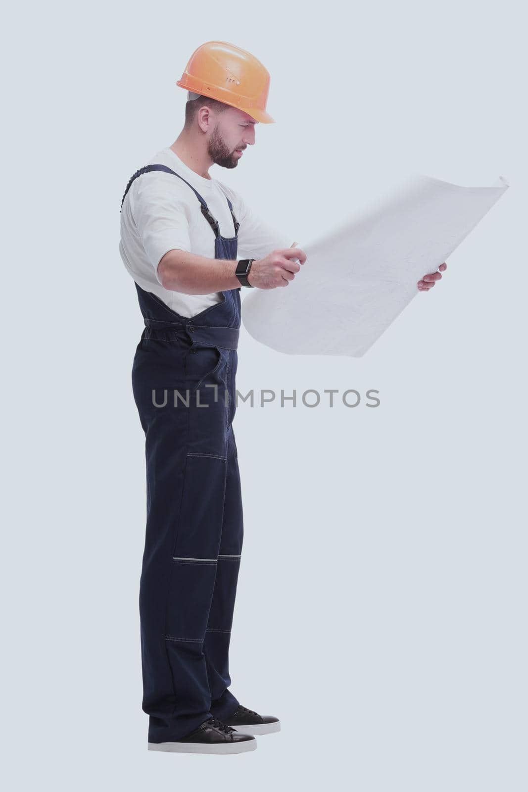 in full growth. competent foreman Builder looking at drawings. isolated on white background