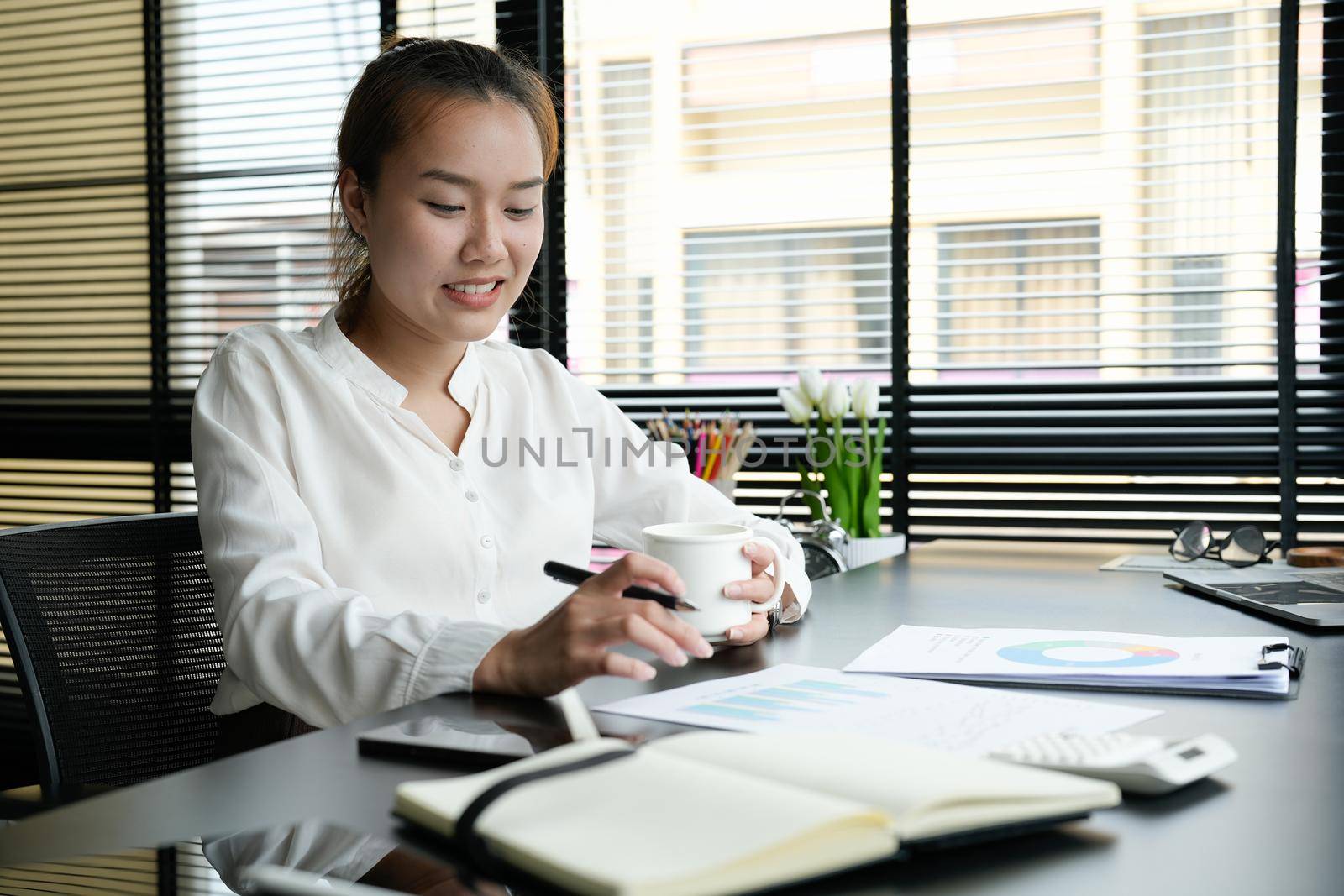 Business accountant asian woman analysis financial report at her office.