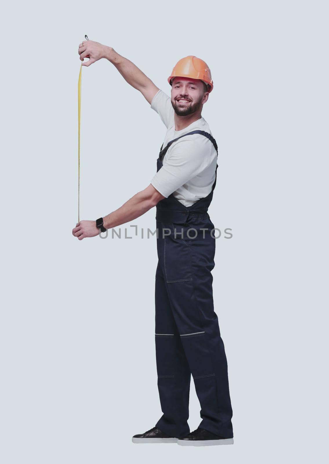 in full growth. man Builder with construction tape measure. isolated on white background