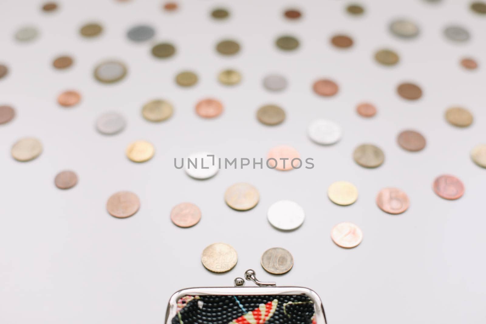 Open purse with different coins isolated on white background top view. Financial crisis, poverty, lack of money