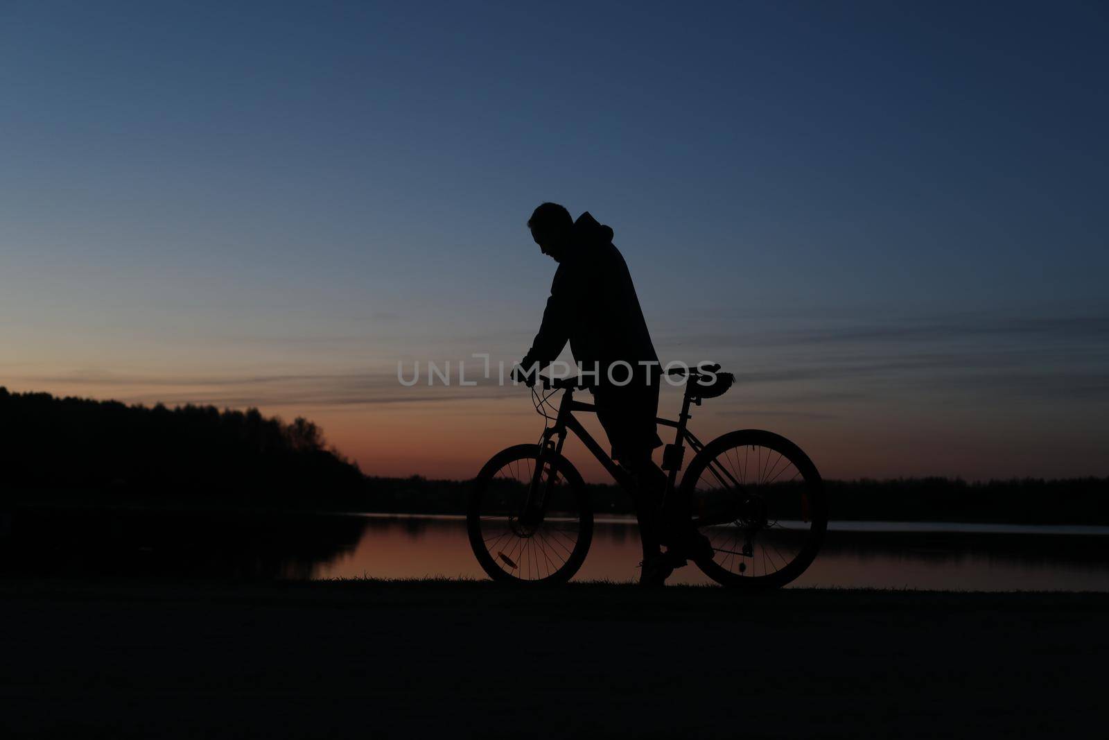 Silhouette of a bicyclist on the beach at sunset by paralisart