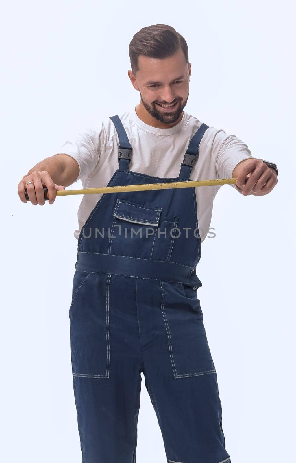 in full growth. smiling man with construction tape measure. isolated on white background