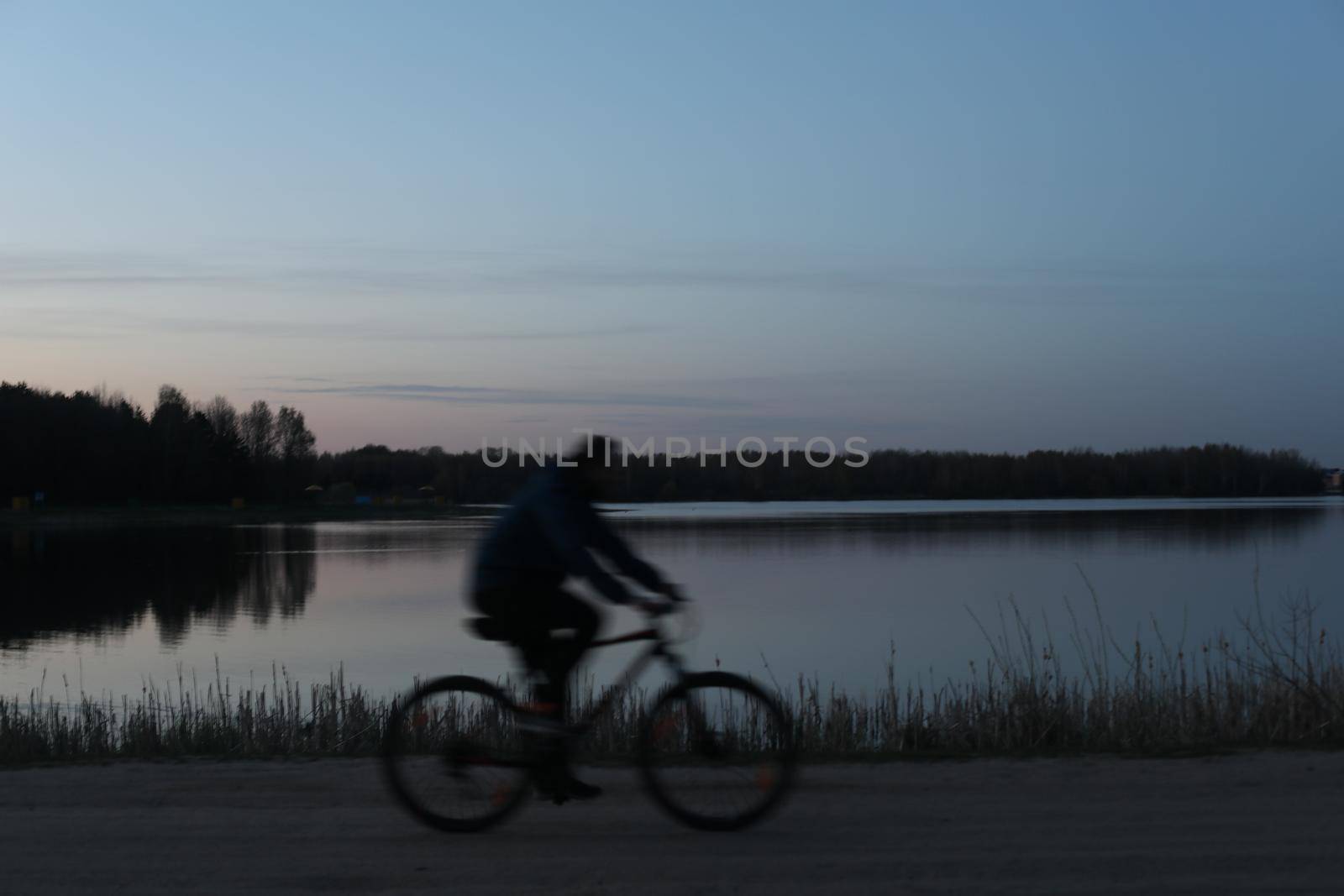Silhouette of a cyclist on the beach at sunset.