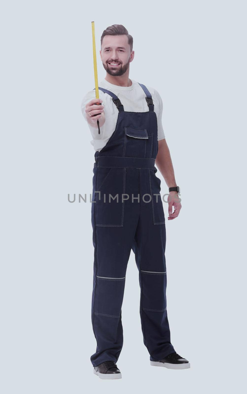 man in overalls with a construction tape measure. isolated on white by asdf