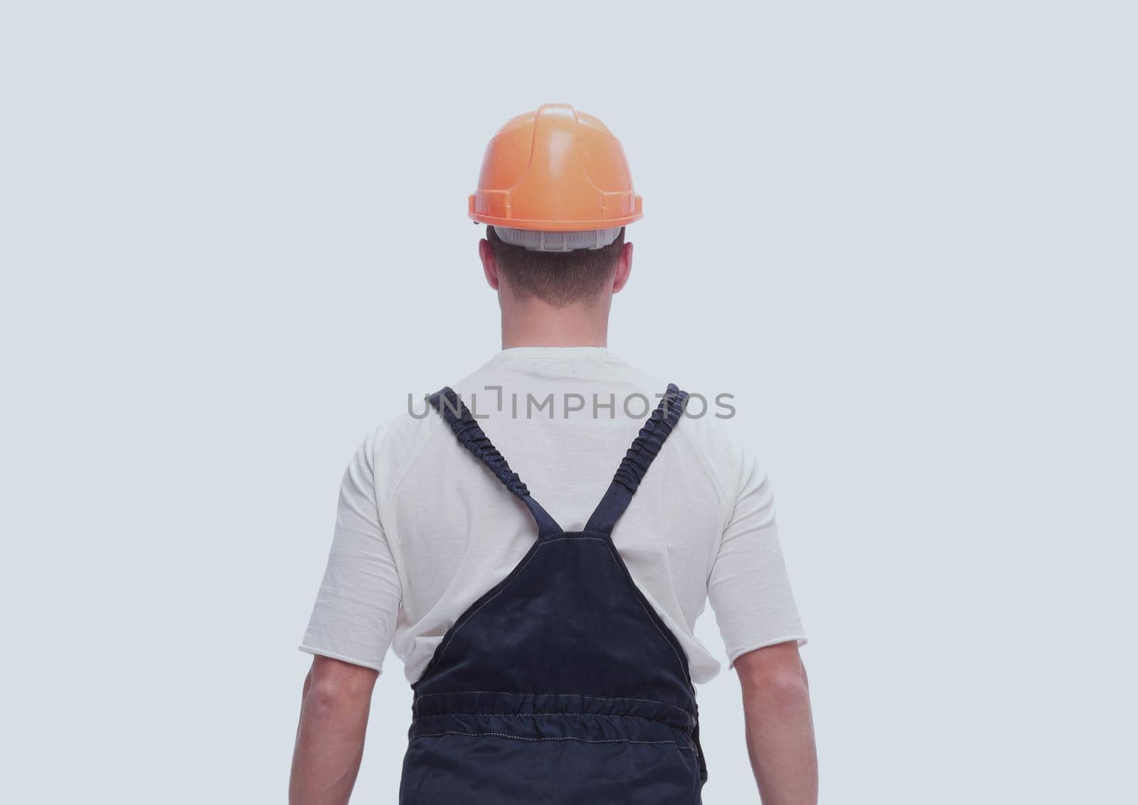 rear view. a man in a work suit looking at a copy of the space . isolated on white background