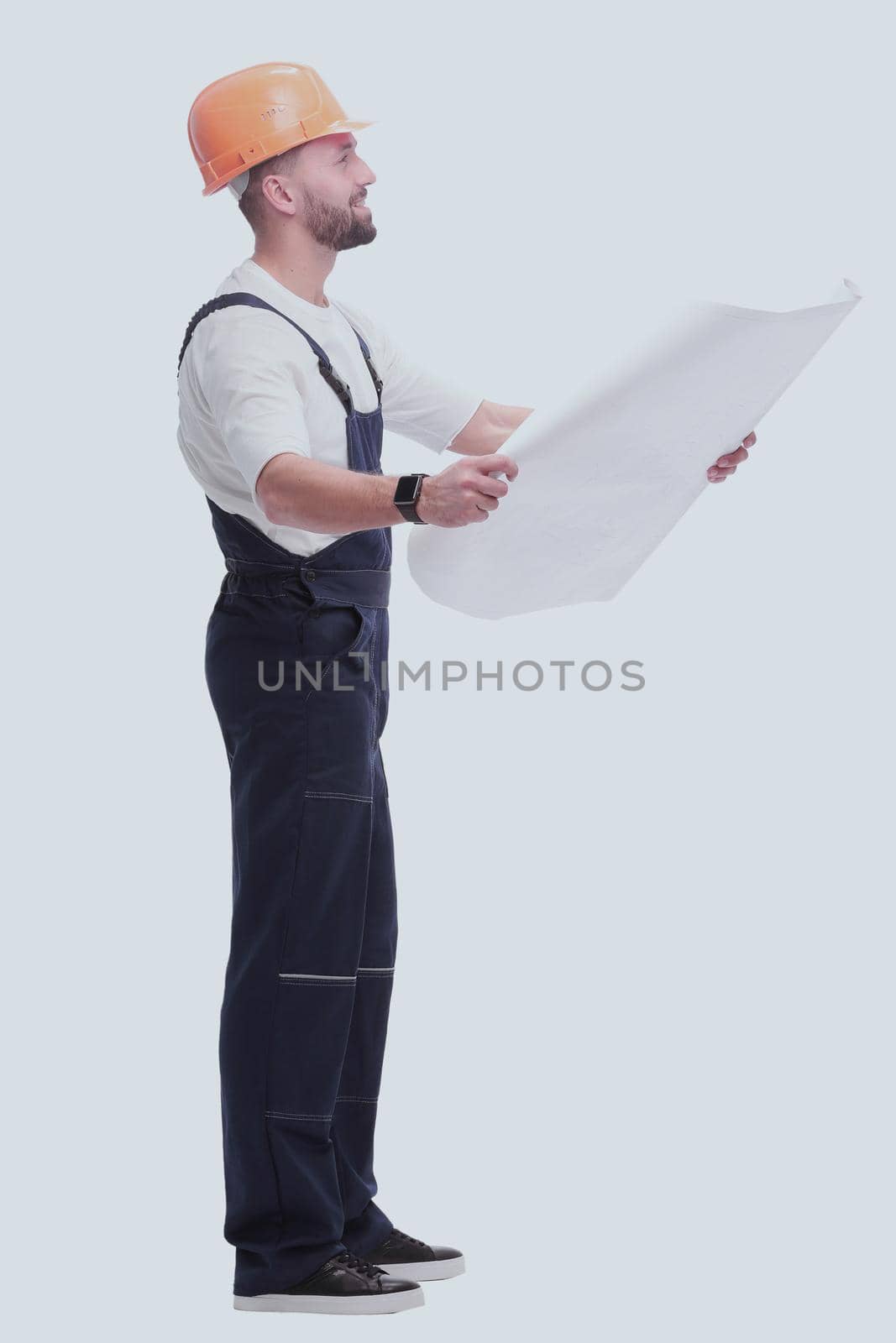 in full growth. competent foreman Builder looking at drawings. isolated on white background