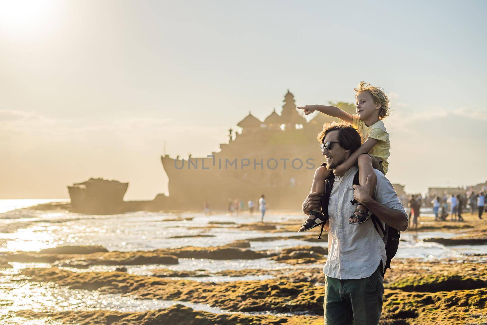 Father and son tourists on the background of Tanah Lot - Temple in the Ocean. Bali, Indonesia. Traveling with children concept.