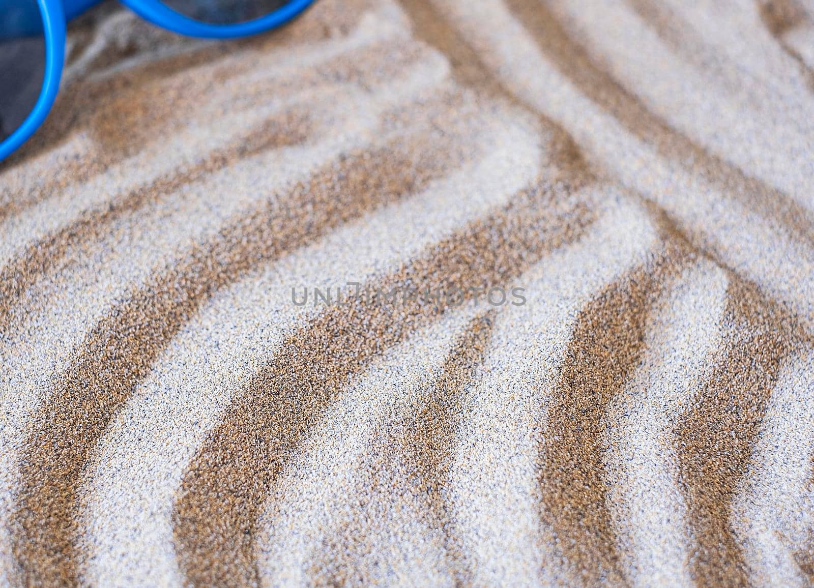 Background wavy sea sand and sunglasses background. Flat lay. Copy space