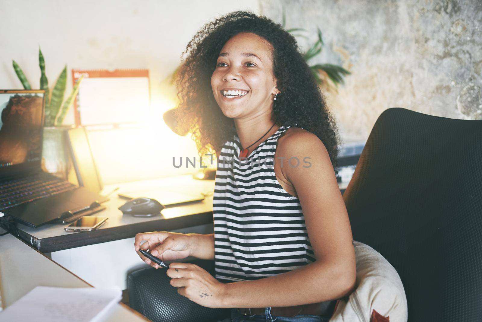 Shot of an attractive young african woman sitting alone and smiling while working from home stock photo