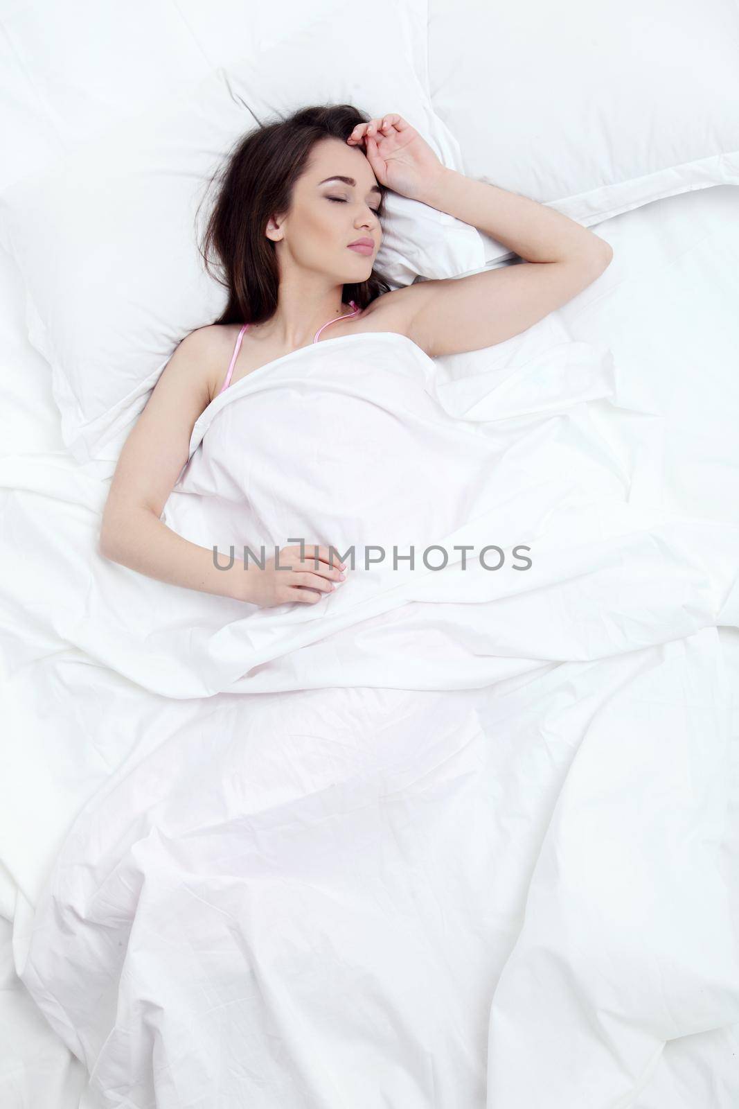 Young beautiful woman sleeping in her bed and relaxing in the morning.