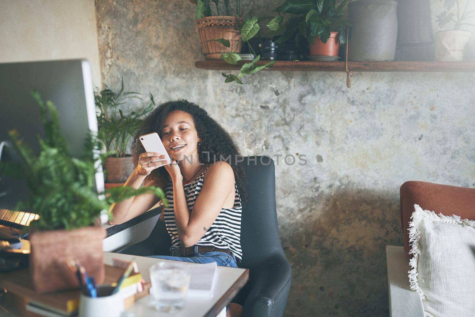 Shot of an attractive young woman sitting alone and using technology while working from home stock photo