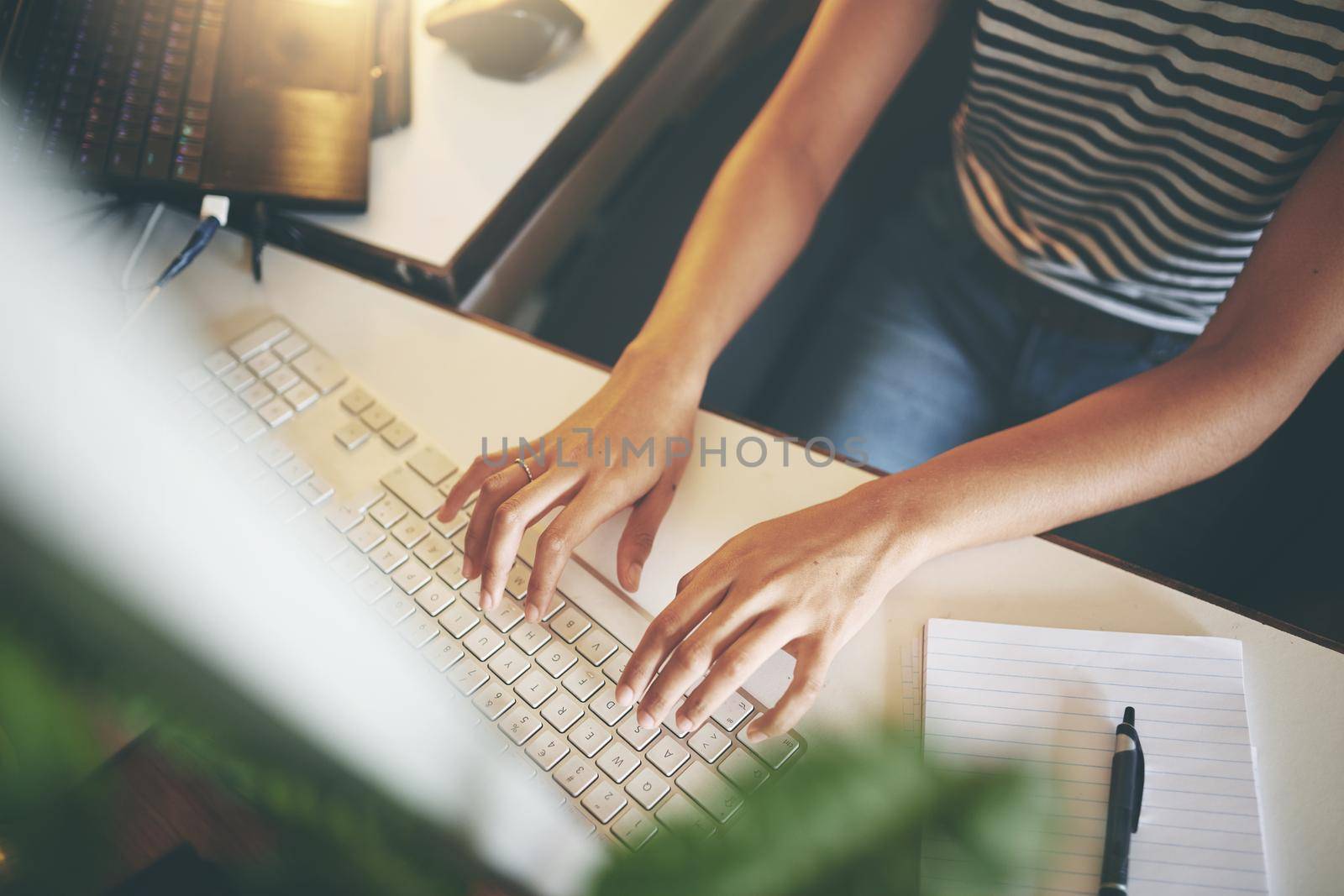 High angle shot of an unrecognizable woman sitting alone and using her computer to work from home stock photo