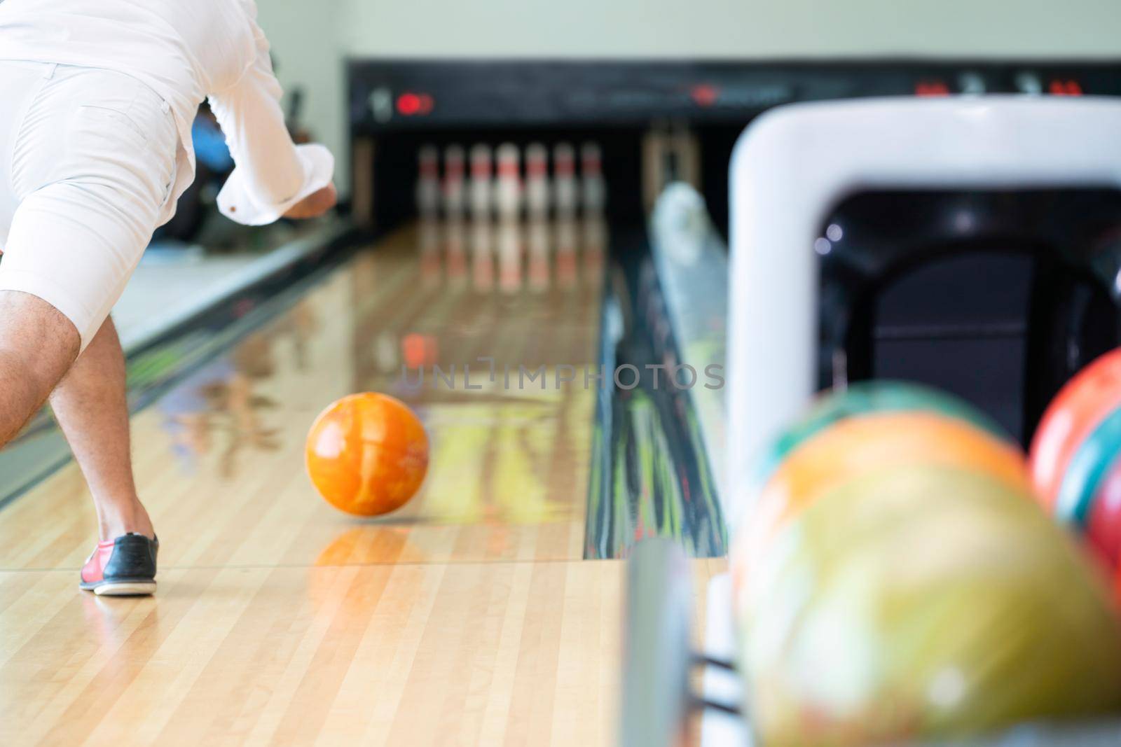 Young man playing bowling at the sport club.
