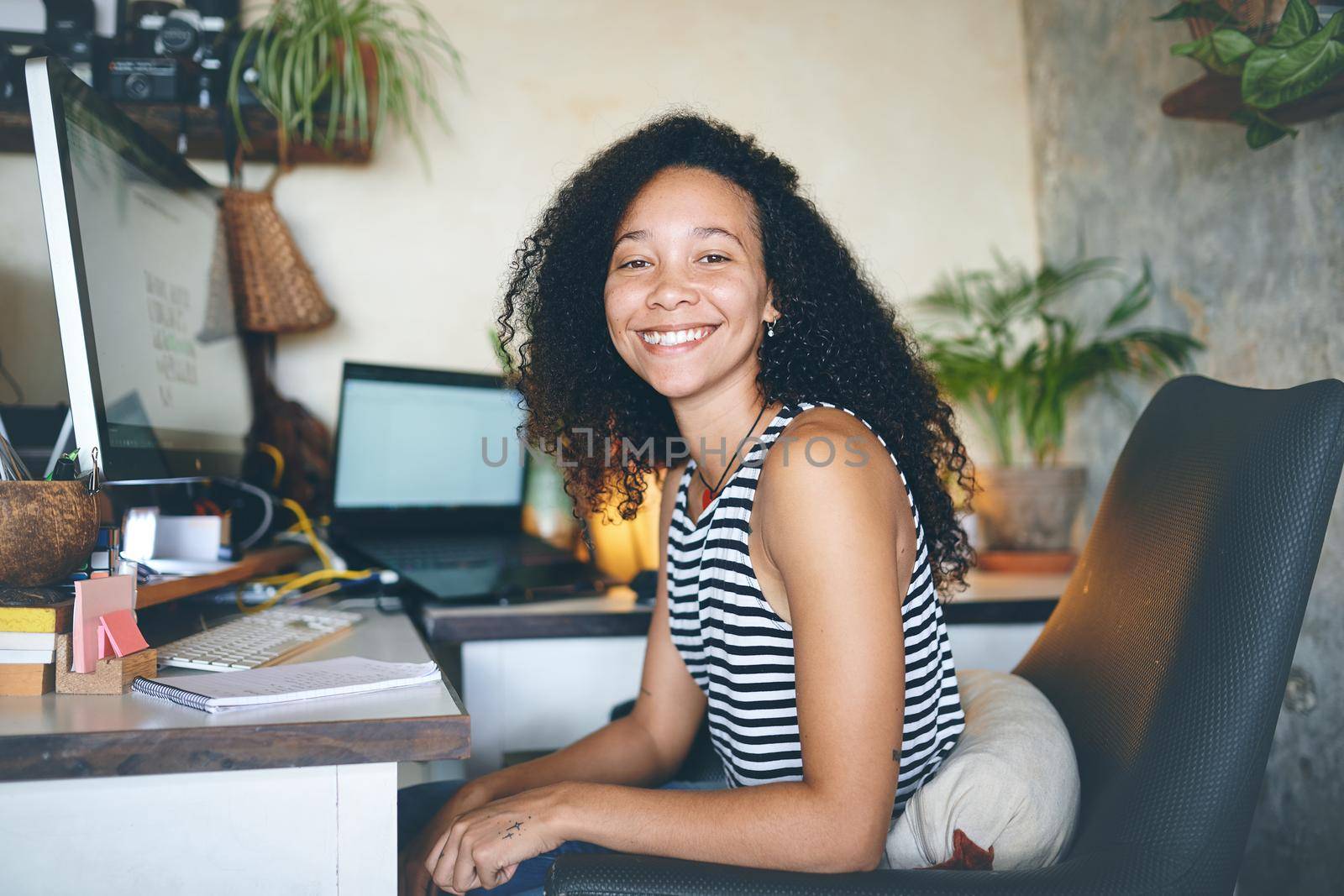 Shot of an attractive young woman smiling at the cameras in her home office