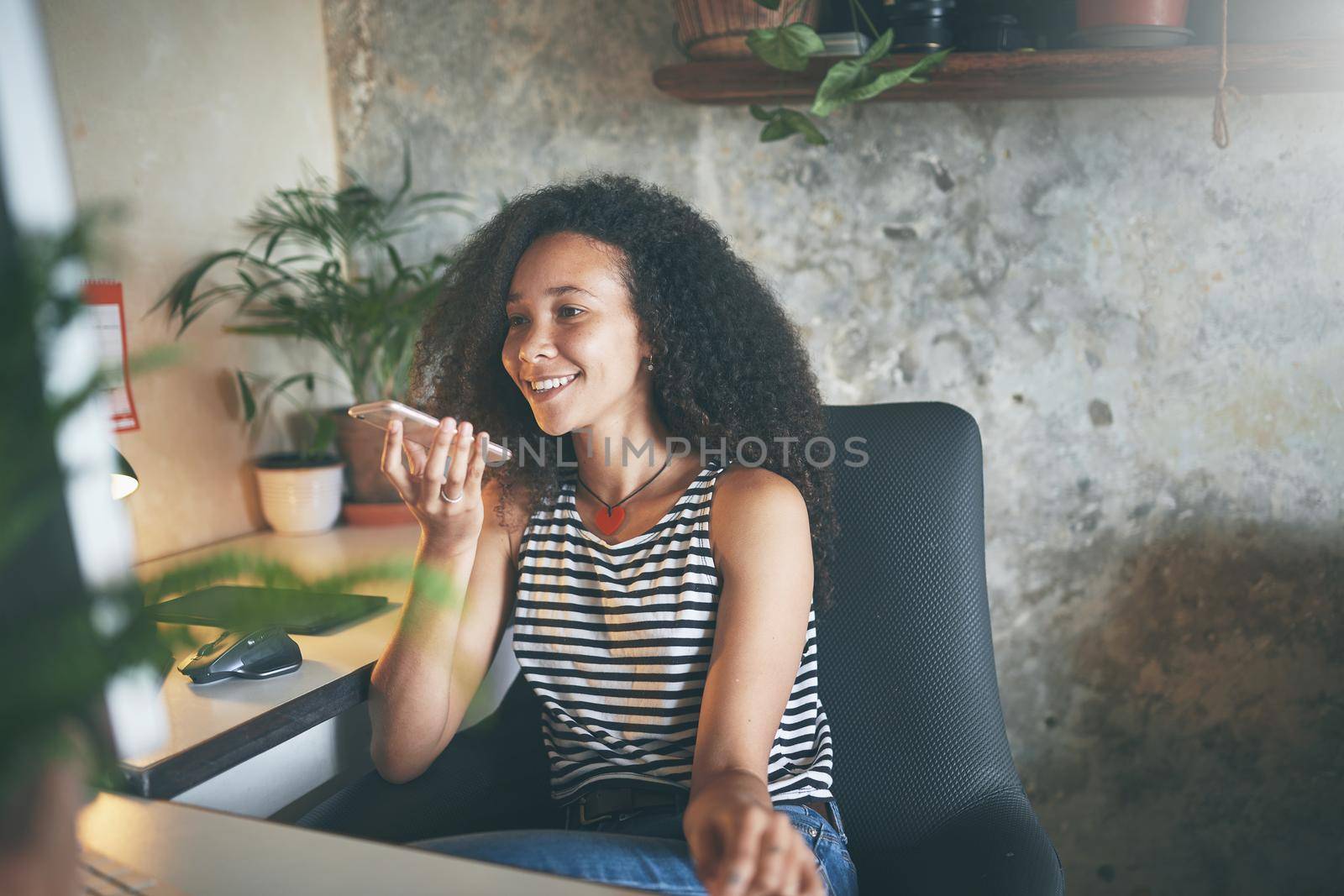 Shot of an attractive young african woman sitting alone and using technology while working from home stock photo