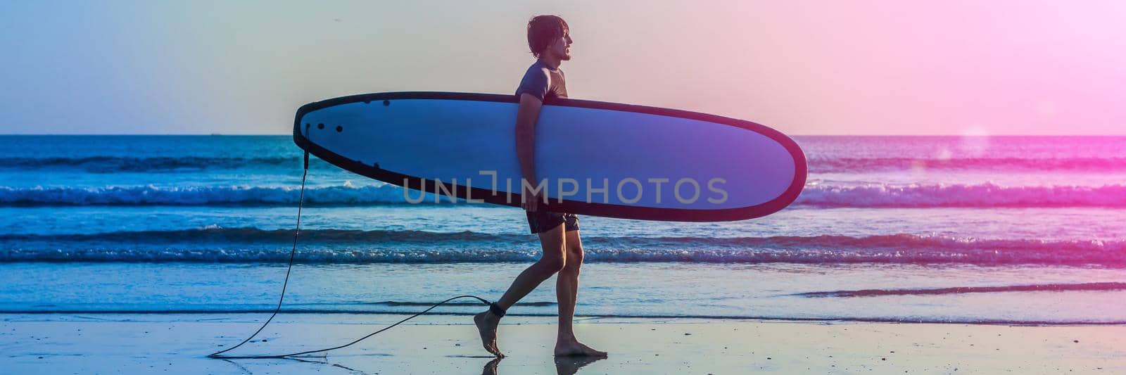 Vacation Silhouette Of A Surfer Carrying His Surf Board Home At Sunset With Copy Space. BANNER, long format