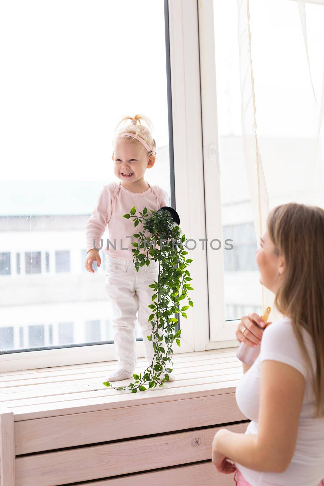 Happy child girl with cochlear implant having fun with her mother - hearing aid for deaf and innovative health technology concept by Satura86