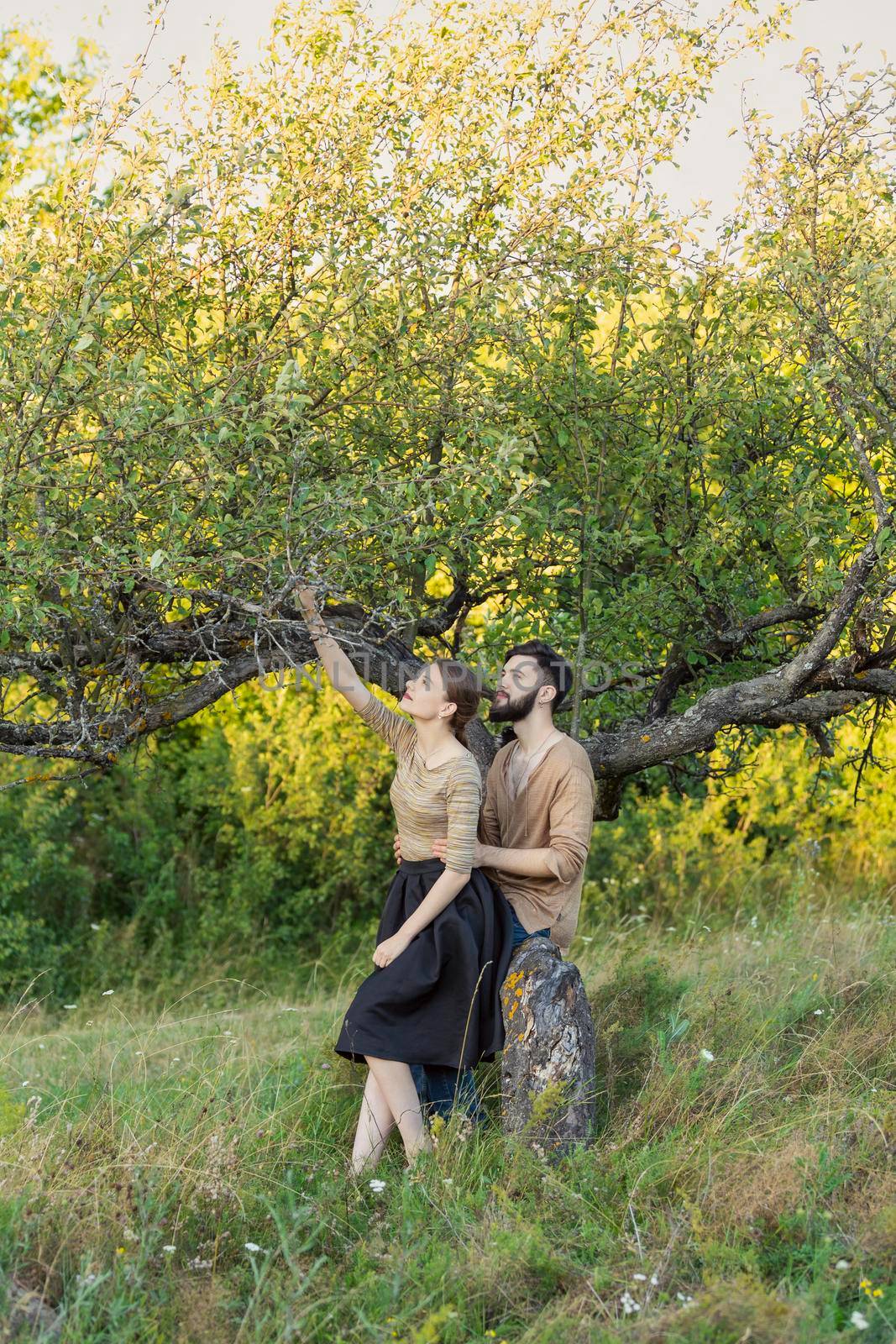 young couple hugging near a tree