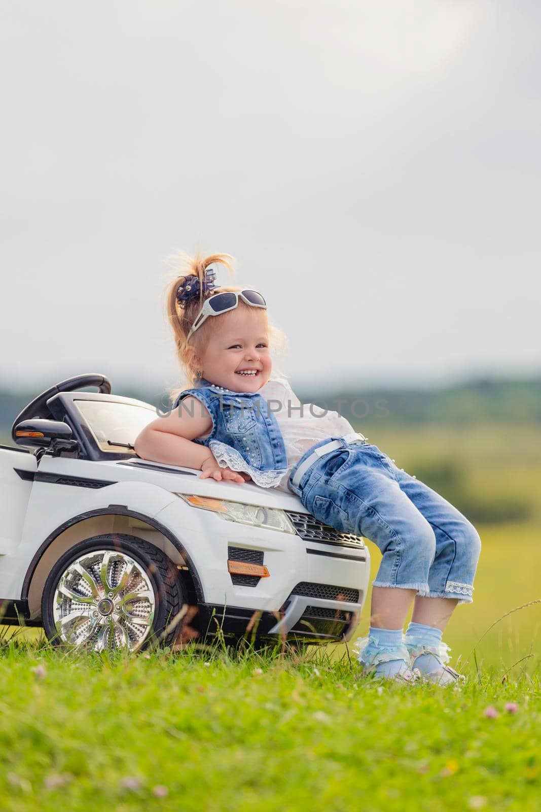girl in sunglasses stands near the car in nature