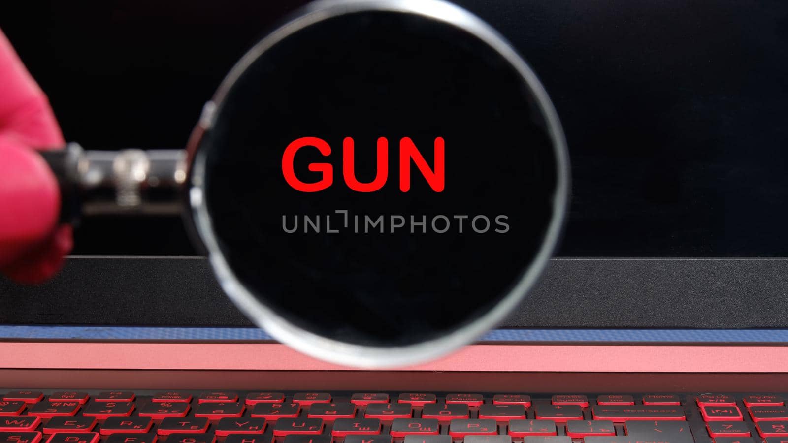 Through a magnifying glass, the inscription GUN is visible. The concept of peace on the planet.