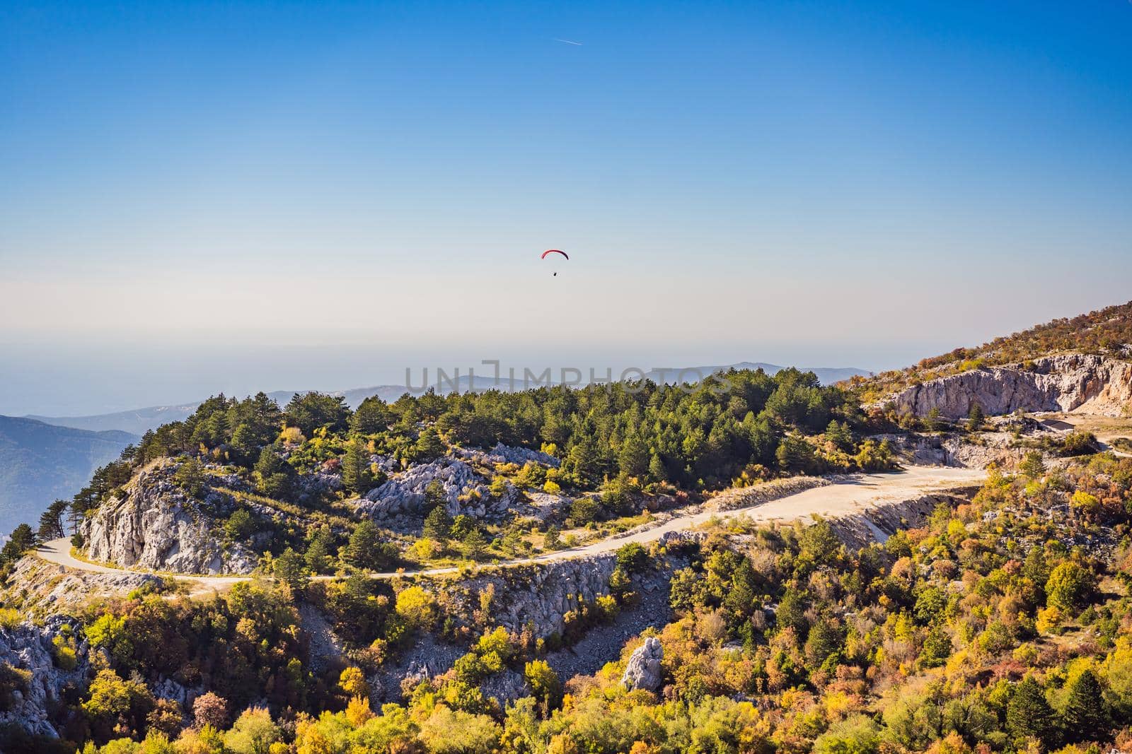 Paraglider flying in the sky, mountain view, Becici, Montenegro by galitskaya