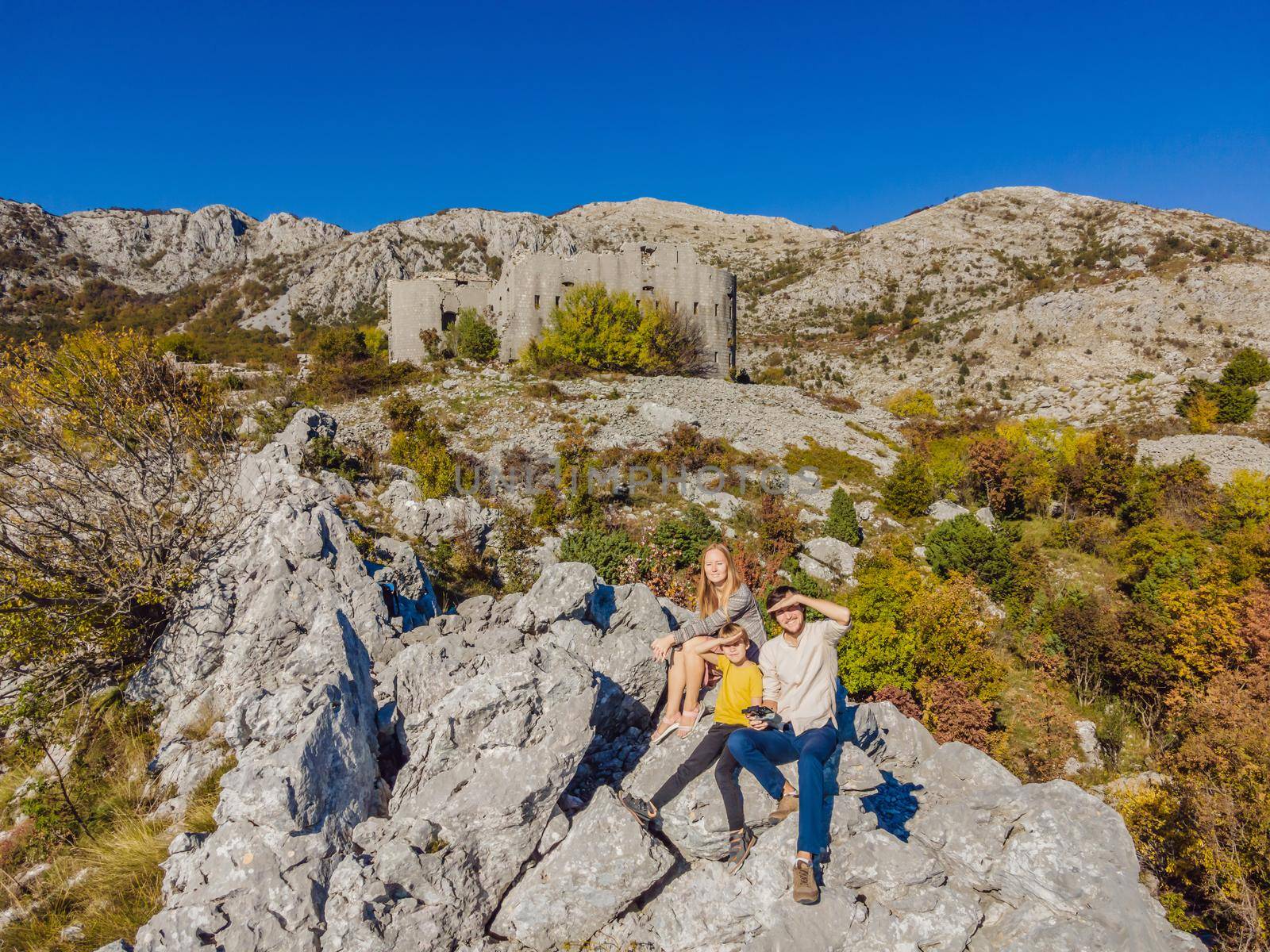 Happy family on the background of Collapsing tower of fortress Kosmac. Travel to Montenegro concept. Ancient Austro-Hungarian fortress built as a defensive structure and an observation post. Montenego by galitskaya