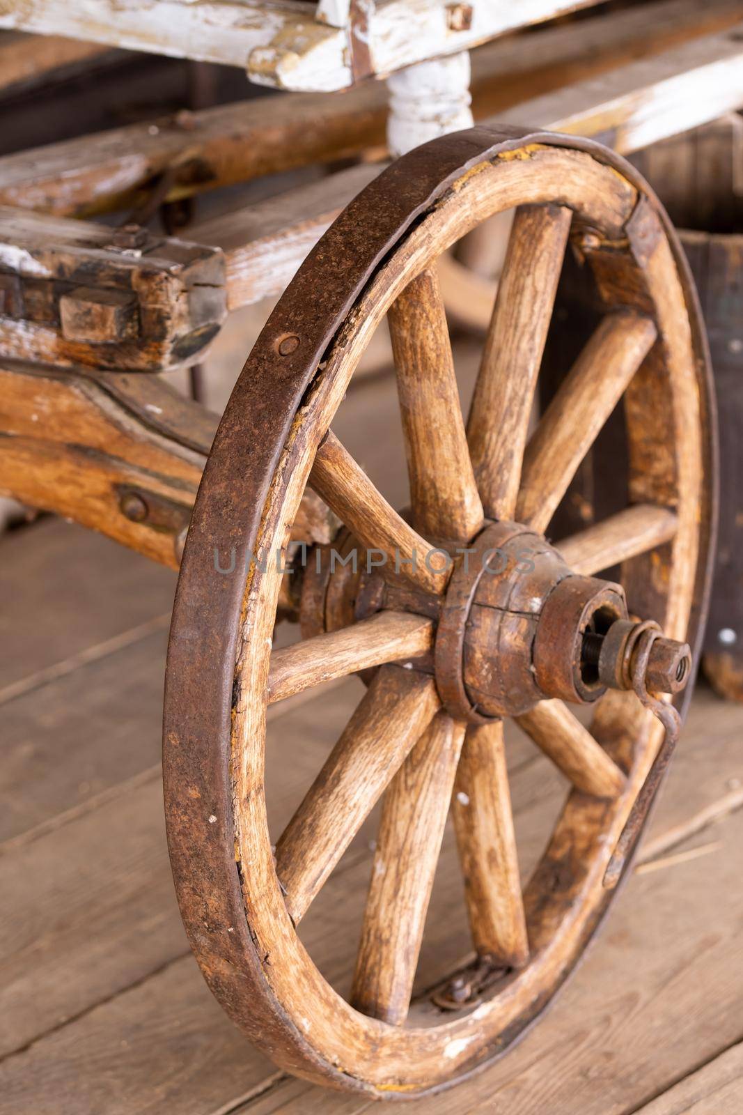 old wooden wheels are on the carriage at the ranch.