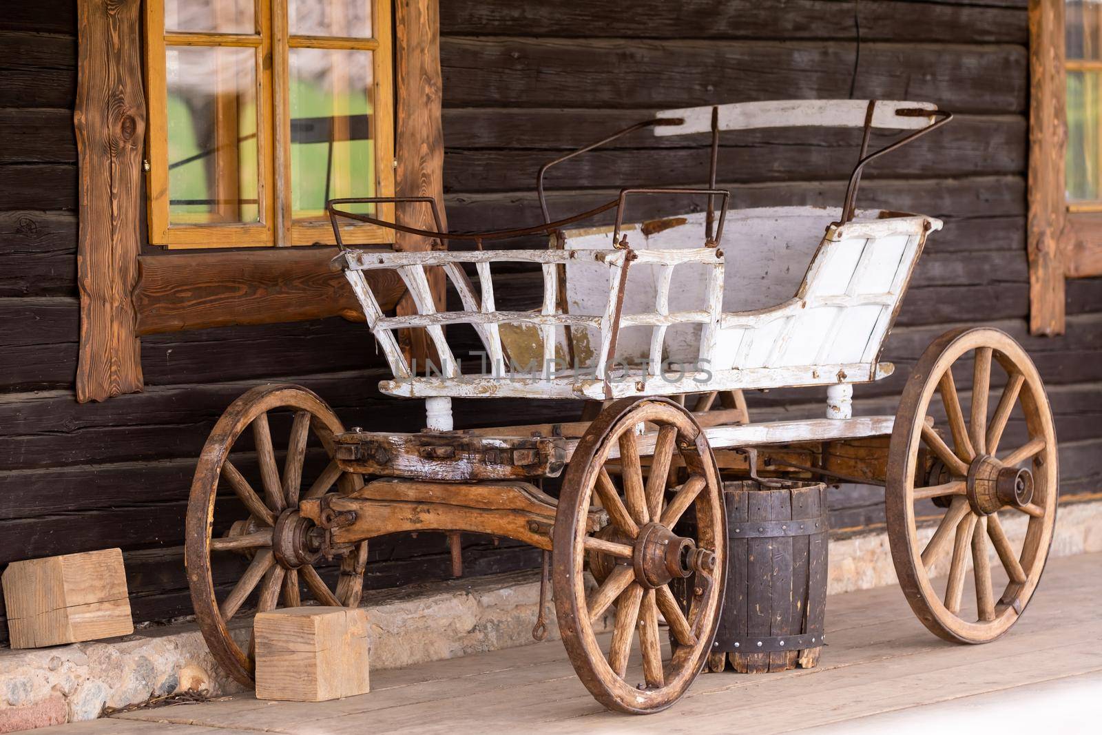 An empty antique carriage stands on a ranch in the wild West.
