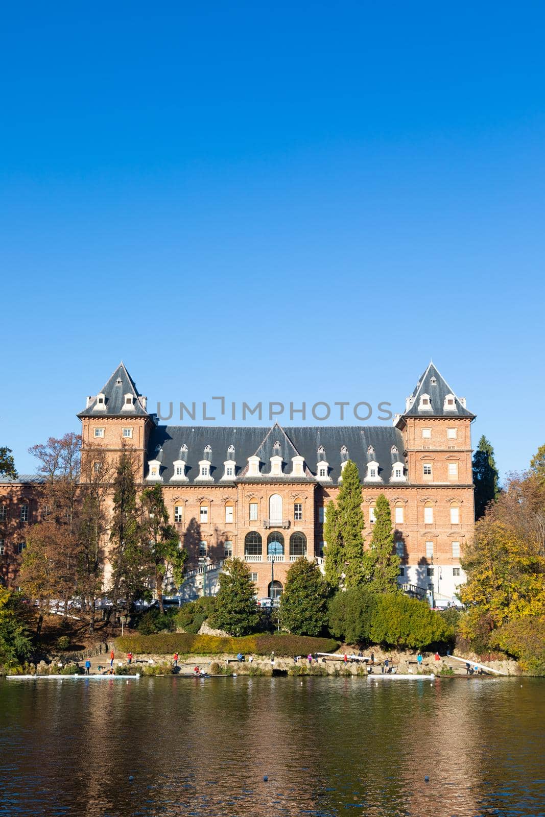 Turin, Italy - Circa November 2021: outdoors panorama with scenic Turin castle and people canoeing in Po' river