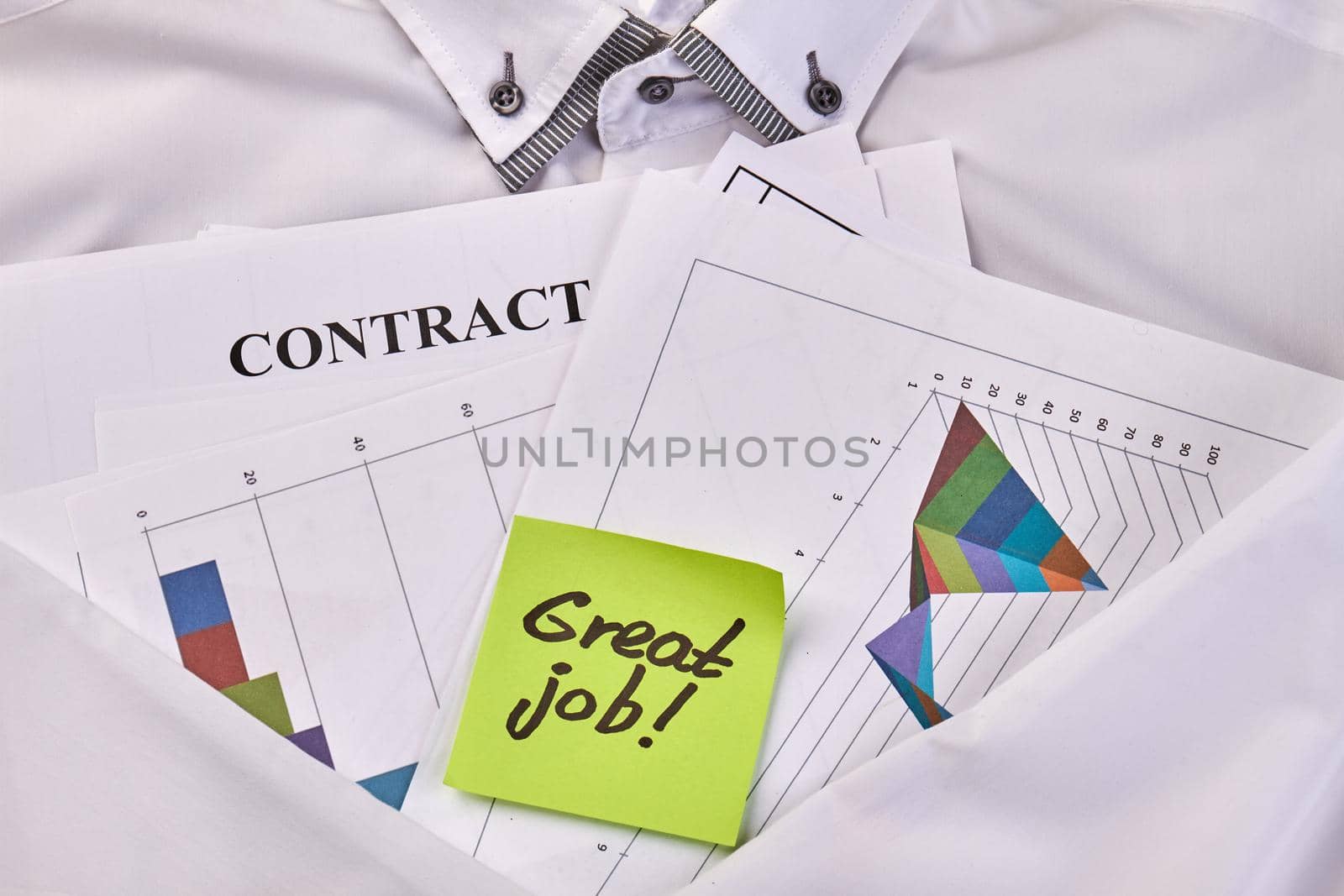 Sticky note with great job text and business papers. Close-up office business papers and white cloth.