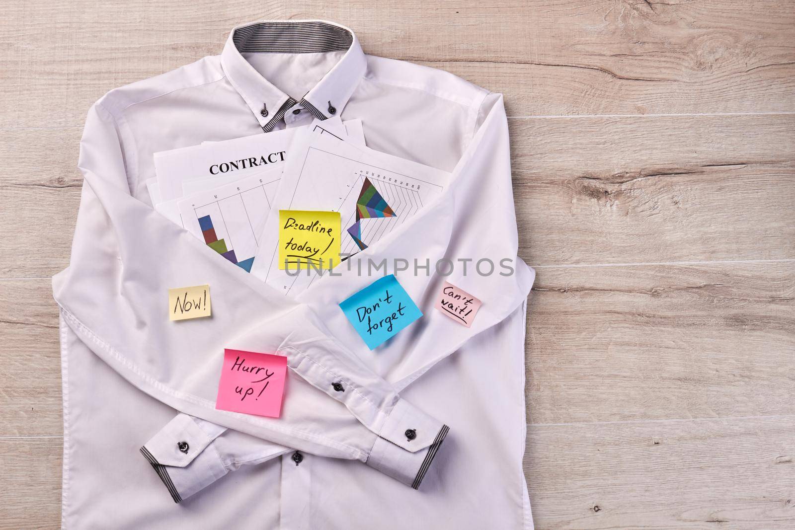 White shirt with sticky notes and business papers. Papers with motivation texts.