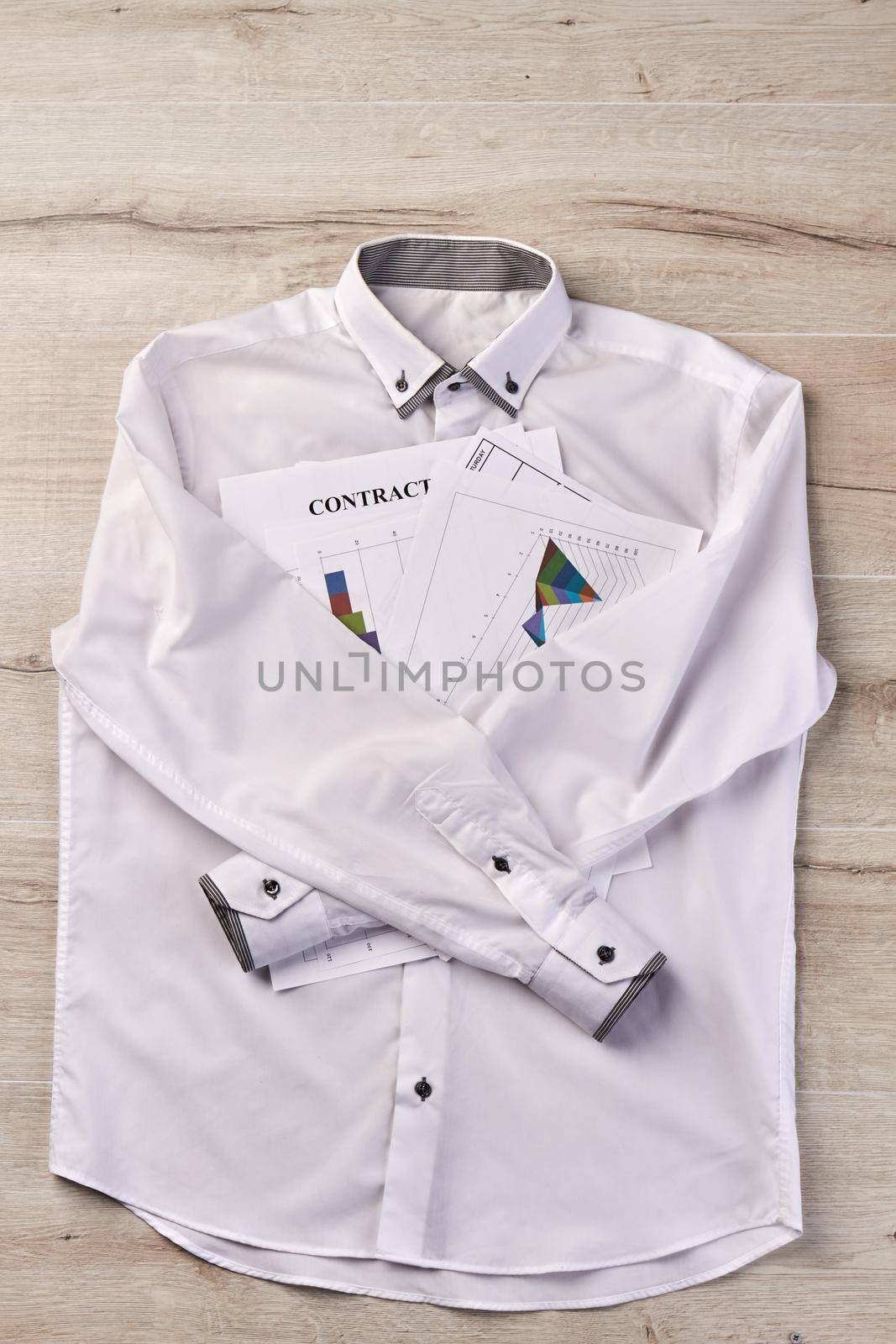 White long sleeve shirt with business papers. Statistic graphs diagrams and contract.