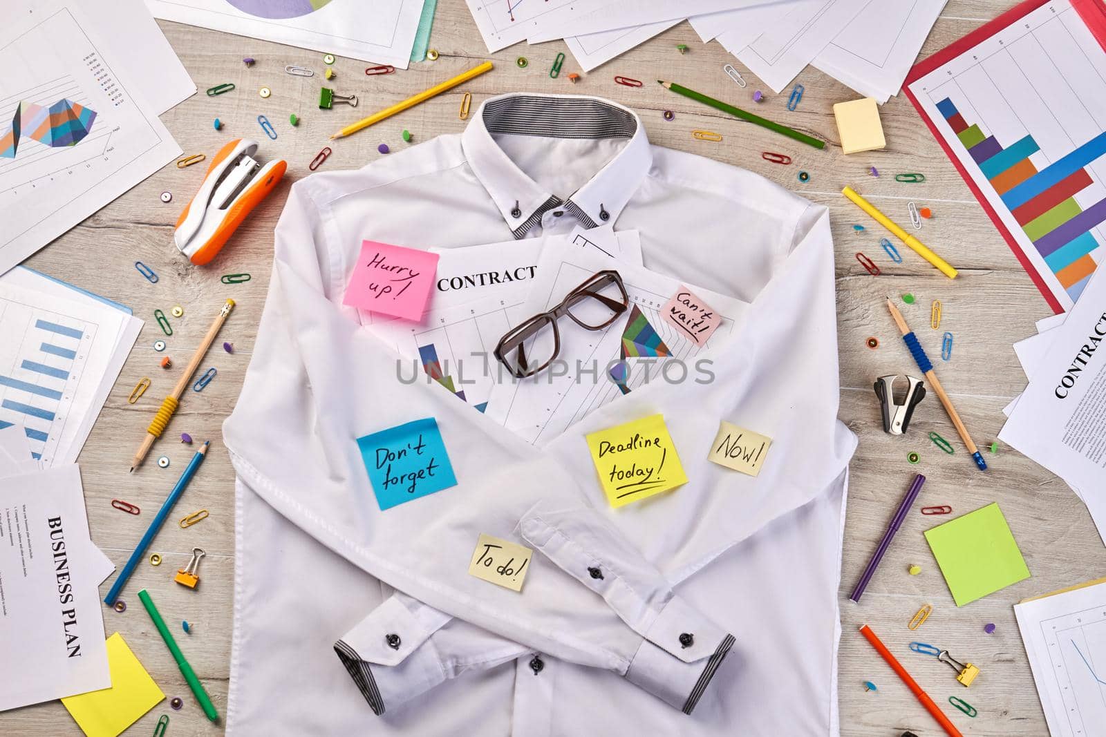 Top view flat lay white shirt and office stationery stuff. Paperclips with stapler and pens.