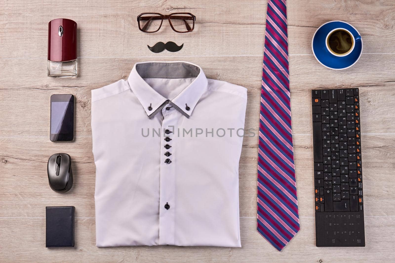 Flat lay top view concept of stylish office worker stuff on the desk. Folded shirt with glasses and tie.