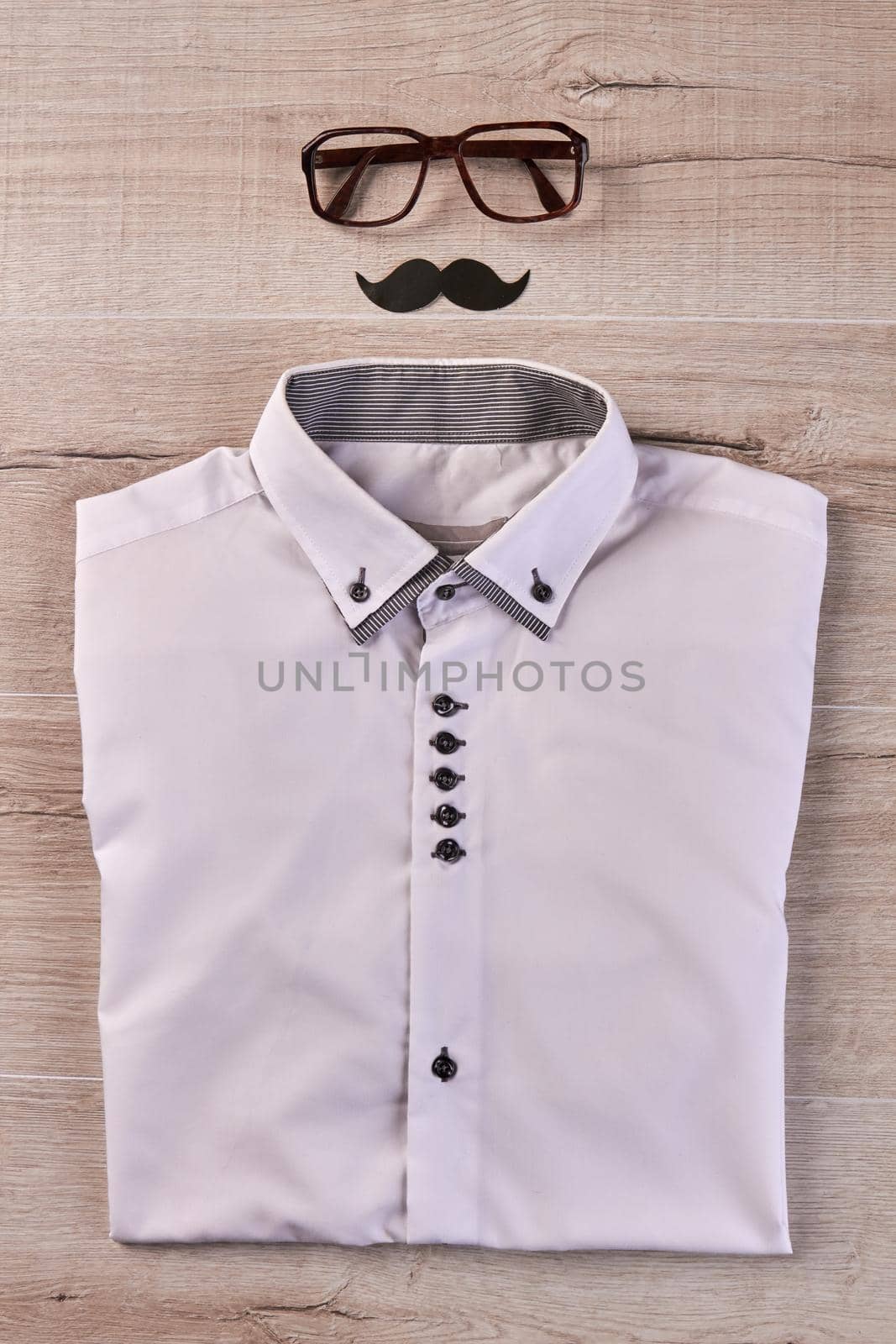 Hipster outfit with glasses and moustache on wooden desk. Top view flat lay.