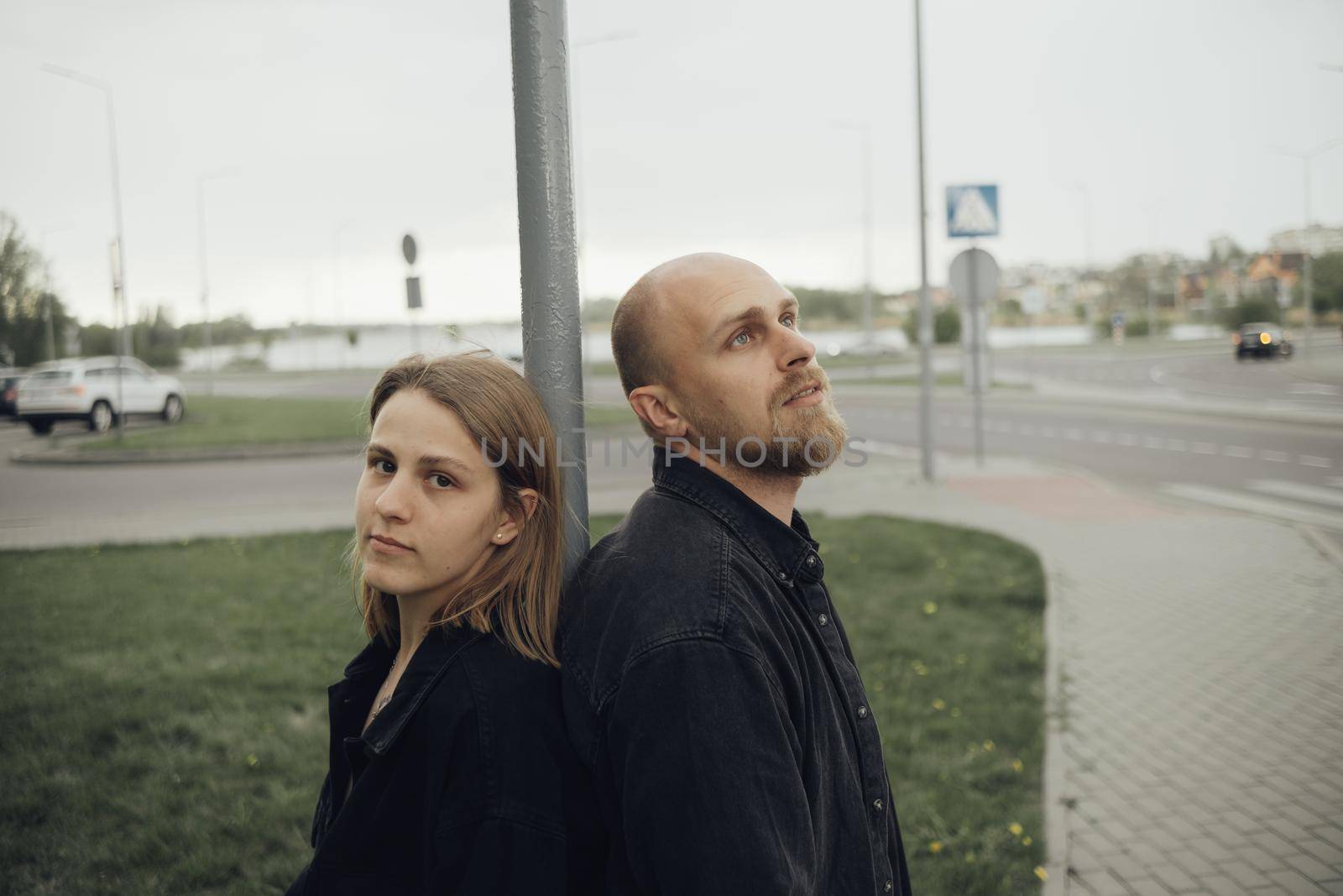 lovers stand on the street back to back with a dreamy look