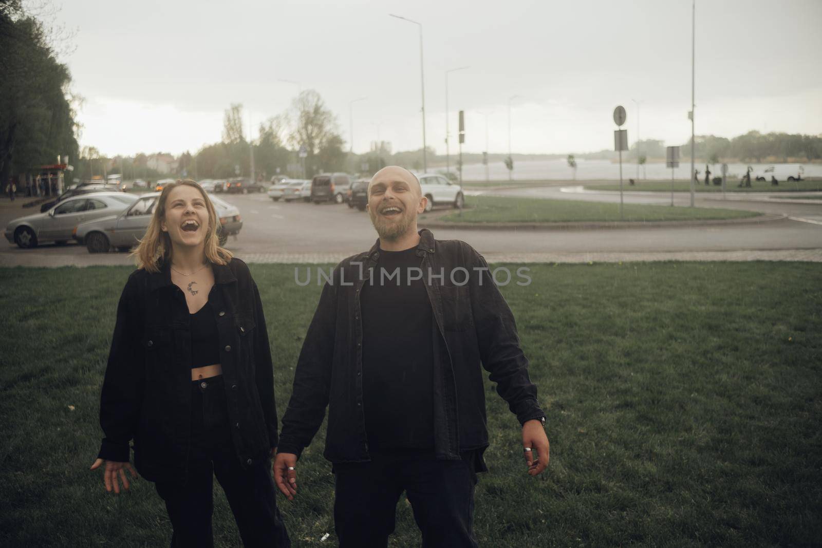a couple of lovers happily walking in the rain by Symonenko