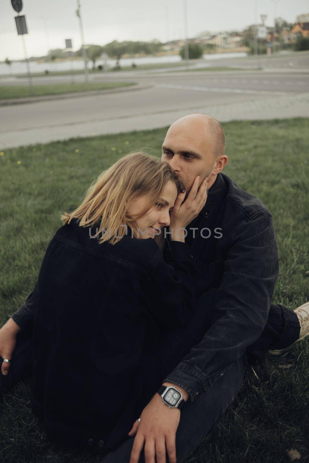 the girl looks at her boyfriend and is about to kiss him. the view from the back of a guy to a girl