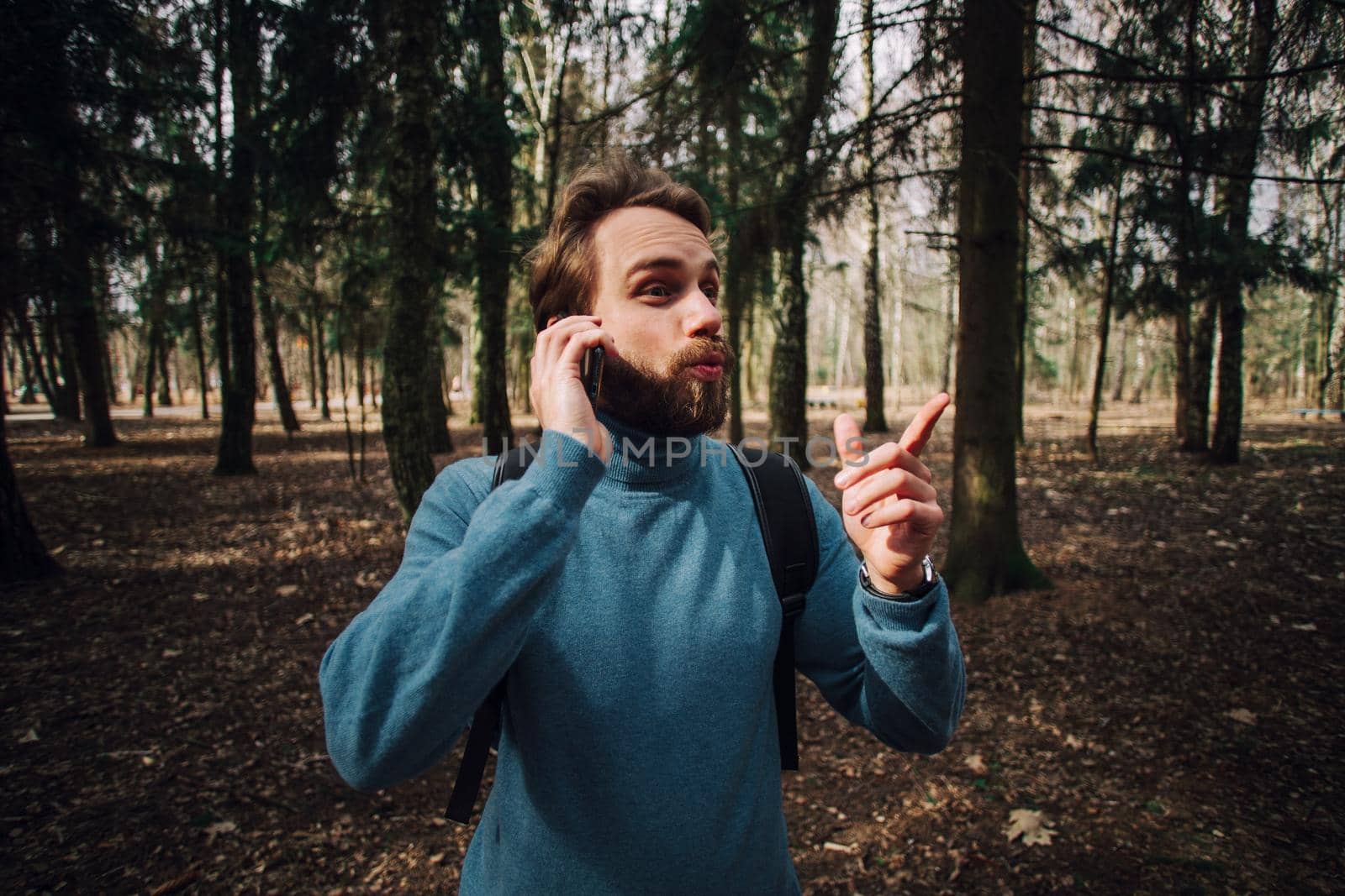 Young adult man talking on the phone standing over white brick wall stressed with hand on head, shocked with shame and surprise face, angry and frustrated. Fear and upset for mistake.