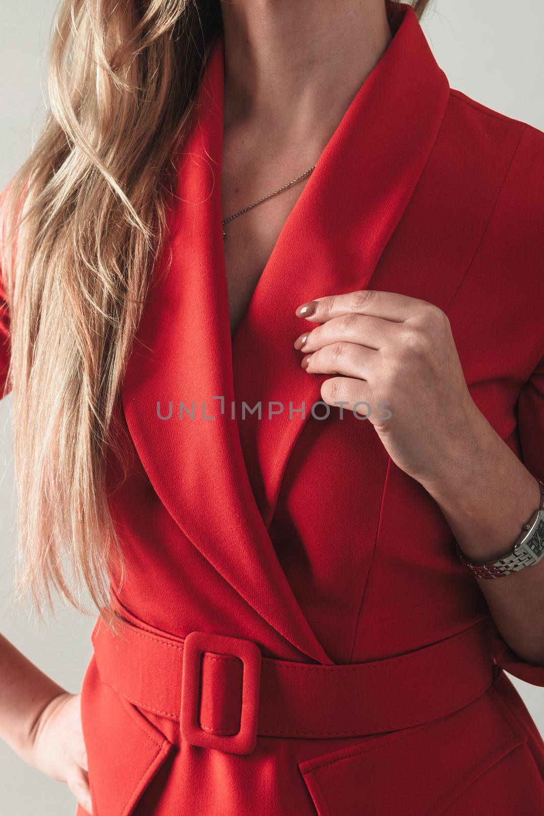 Close up portrait of attractive smiling businesswoman at workplace in a red jacket