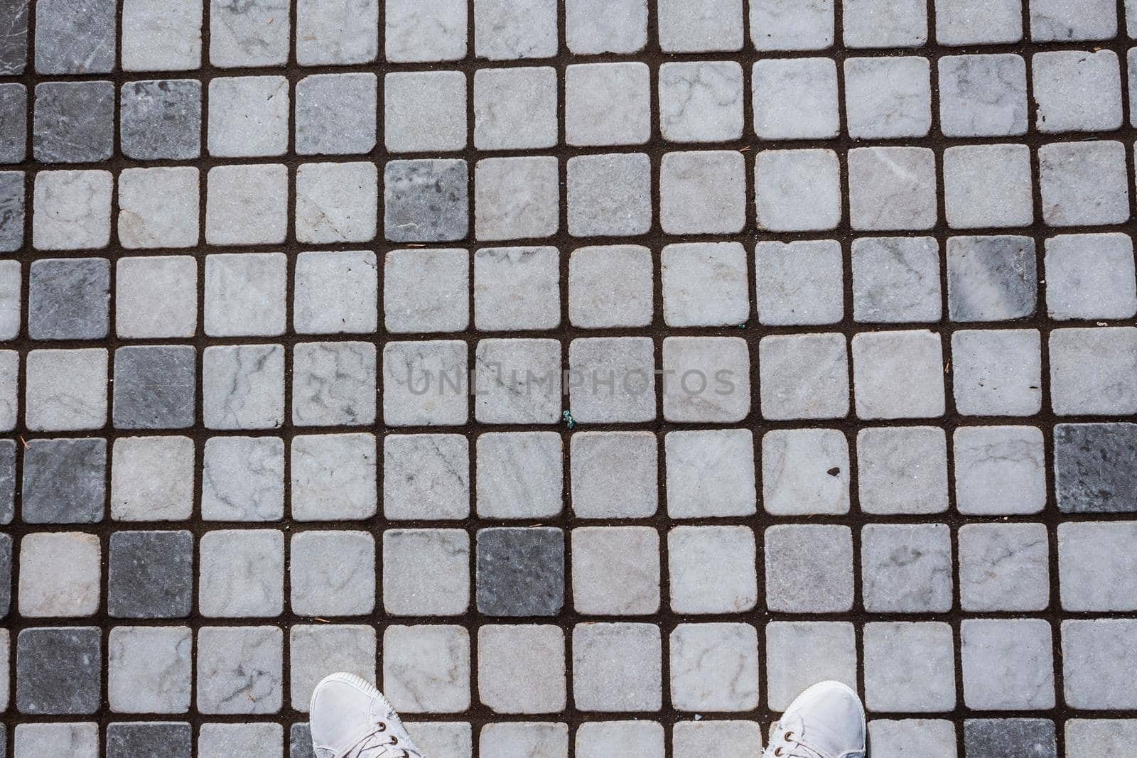 Weathered Wall Background. Old dirty wall covered with thin ceramic square tiles. White gray light blue color. Vintage style. Clay ceramic tiles. Old house outside. Worn and dusty surface of building by JuliaDorian