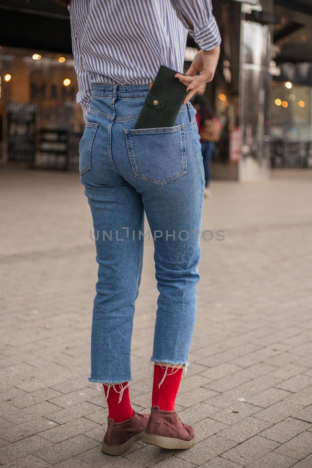 Confident woman posing in save keeping your wallet in the back pocket in pants