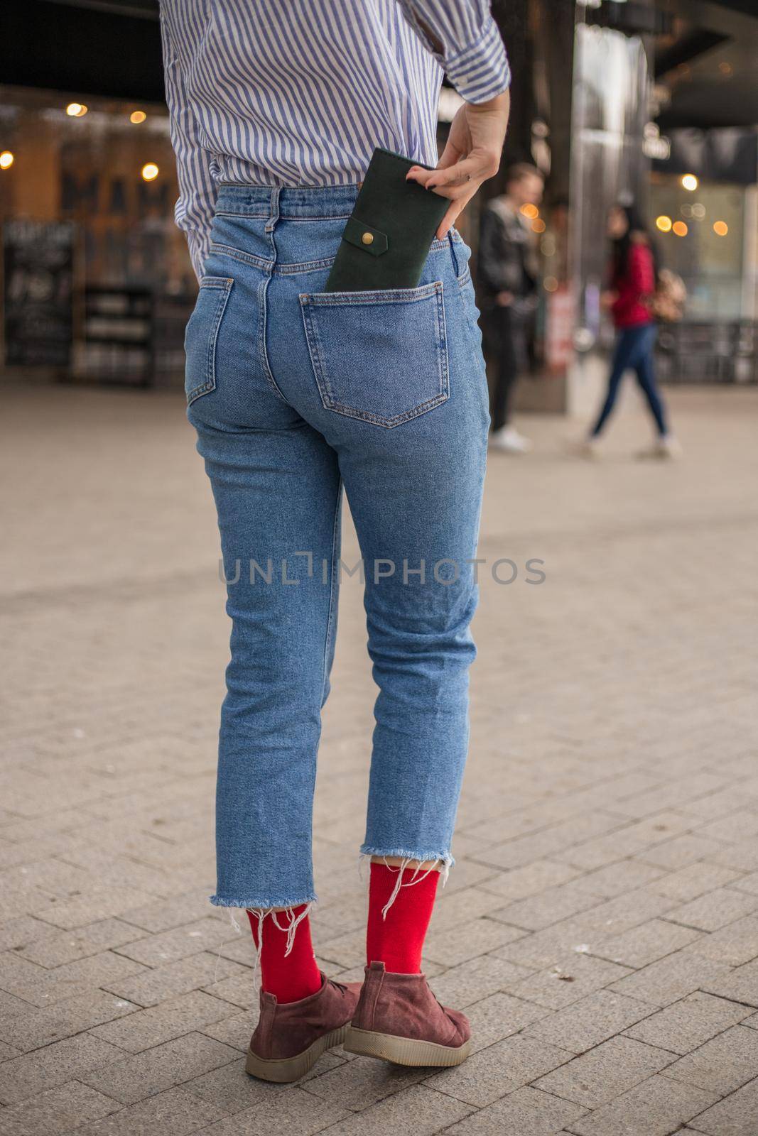 Confident woman posing in save keeping your wallet in the back pocket by Symonenko