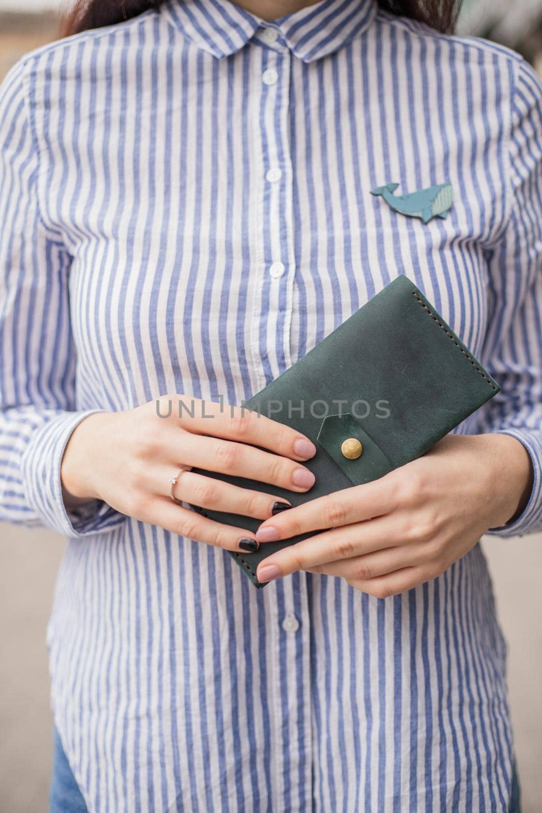 Sky blue handbag purse and beautiful woman hand with manicure. blurred background