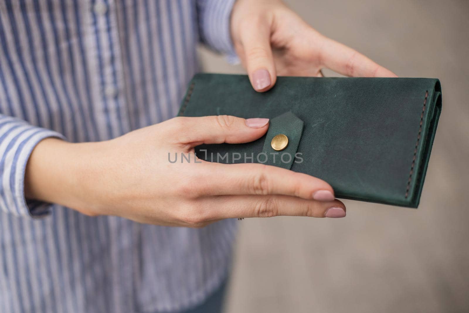 Sky blue handbag purse and beautiful woman hand with manicure. blurred background