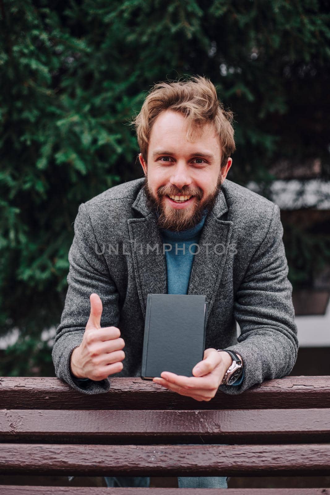 Portrait handsome bearded man, reading book and relaxing. Blurred background.Horizontl, film effect. by Symonenko