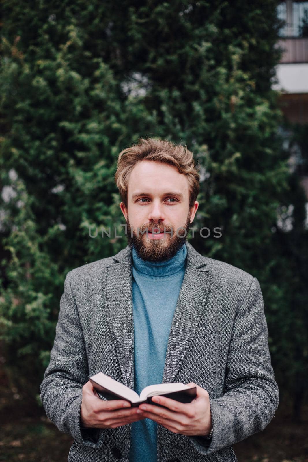 Portrait handsome bearded man, reading book and relaxing. Blurred background.Horizontl, film effect. by Symonenko