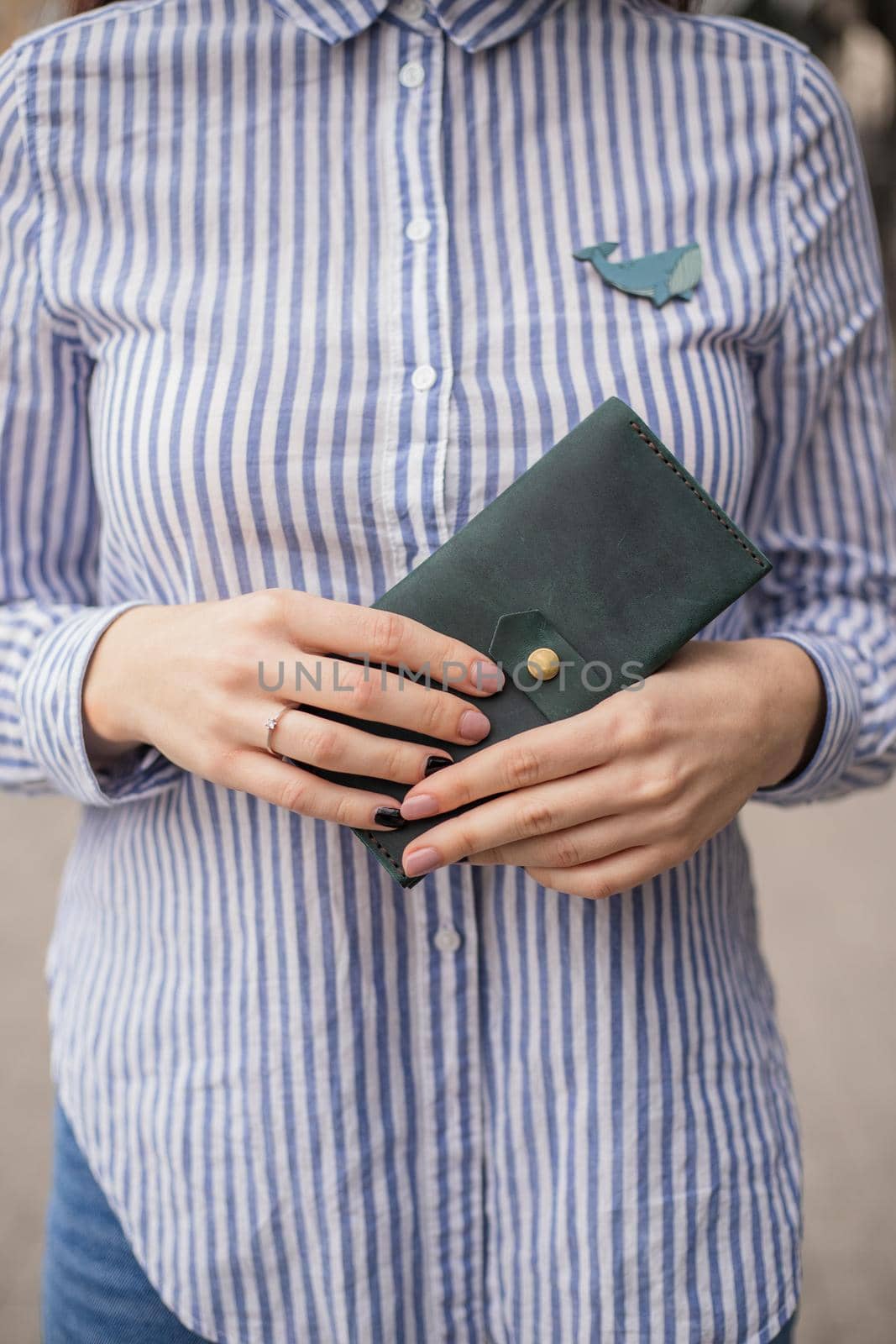 Sky blue handbag purse and beautiful woman hand with manicure. blurred background