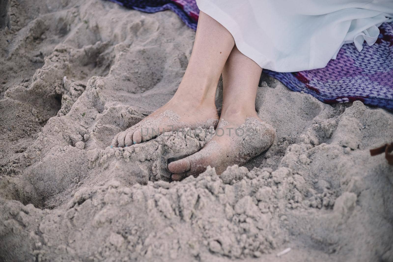 Woman tanned legs on sand beach. Travel concept. Happy feet in tropical by Symonenko